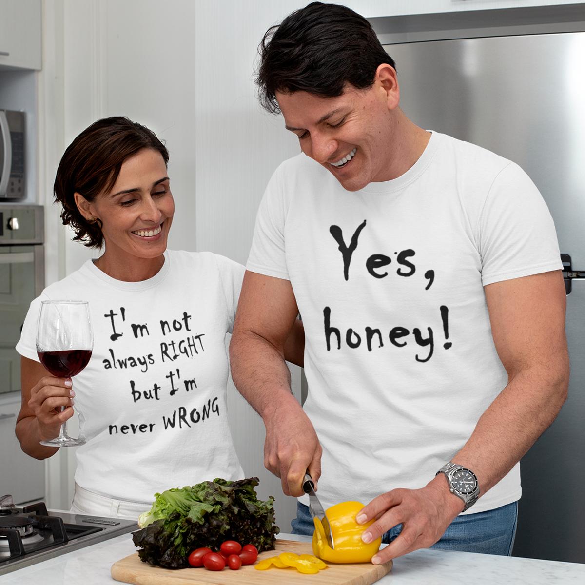 Cuplu zâmbind în bucătărie purtând set de tricouri albe asortate; ea ține un pahar cu vin și poartă mesajul „I'm not always RIGHT but I'm never WRONG”, el taie legume și poartă tricoul cu „Yes, honey!”.