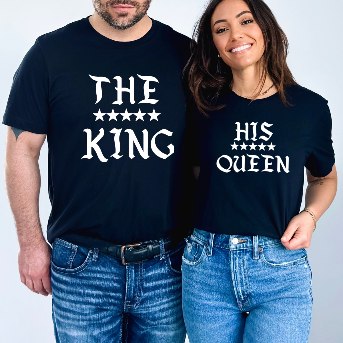 Tricouri negre de cuplu imprimate cu text gotic alb "THE KING" și "HIS QUEEN" și cinci stele albe.